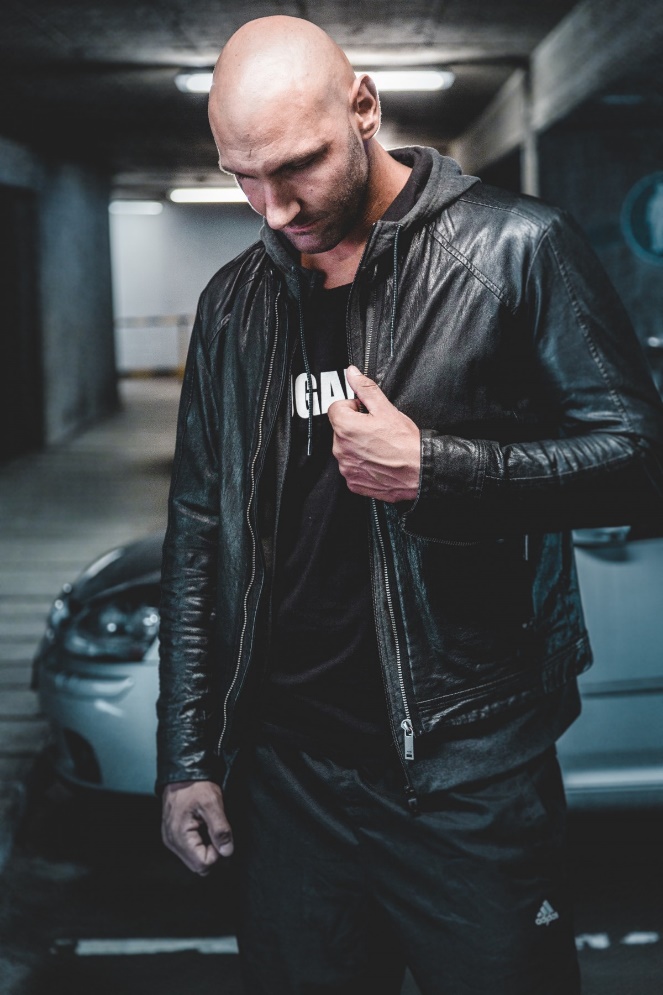 bald black leather jacket car fashion indoors lights man parking deck wear